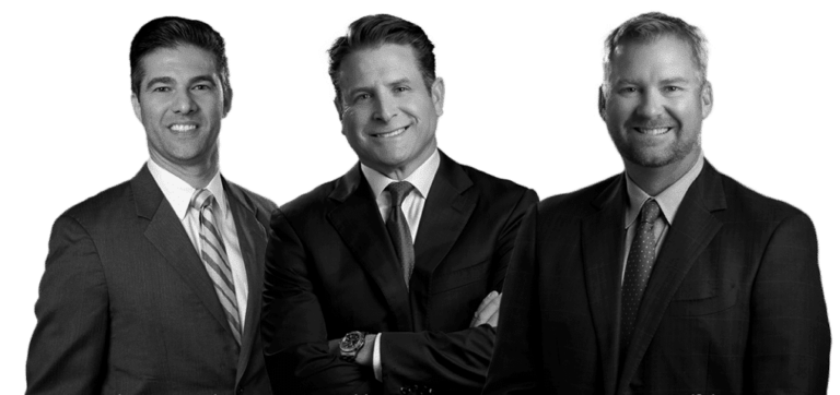 Image of three male warner law office attorneys wearing black suits with a smile on their face