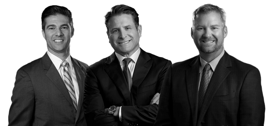 Image of three male warner law office attorneys wearing black suits with a smile on their face