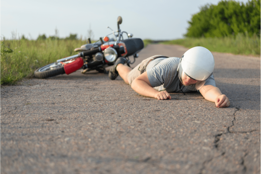 A man involved in a hit and run with his bike lying on the ground unconcious