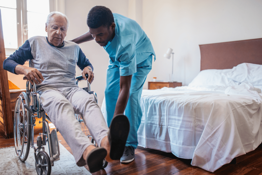 A male nurse helping an aged man on the wheelchair