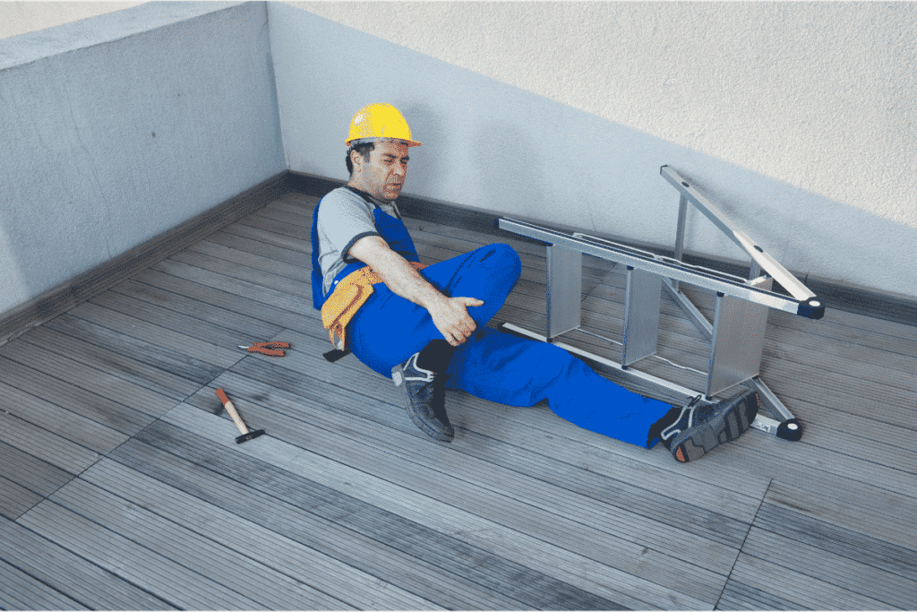 A man holding his leg after falling off a ladder