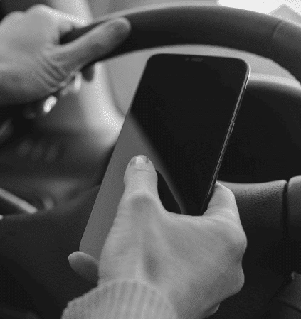 Woman driving while using her phone